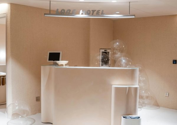 Elegant minimalist hotel lobby featuring a modern reception desk and transparent decorative spheres.